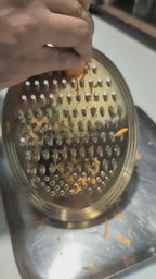 Meshverse gold oval grater shredding fresh carrots