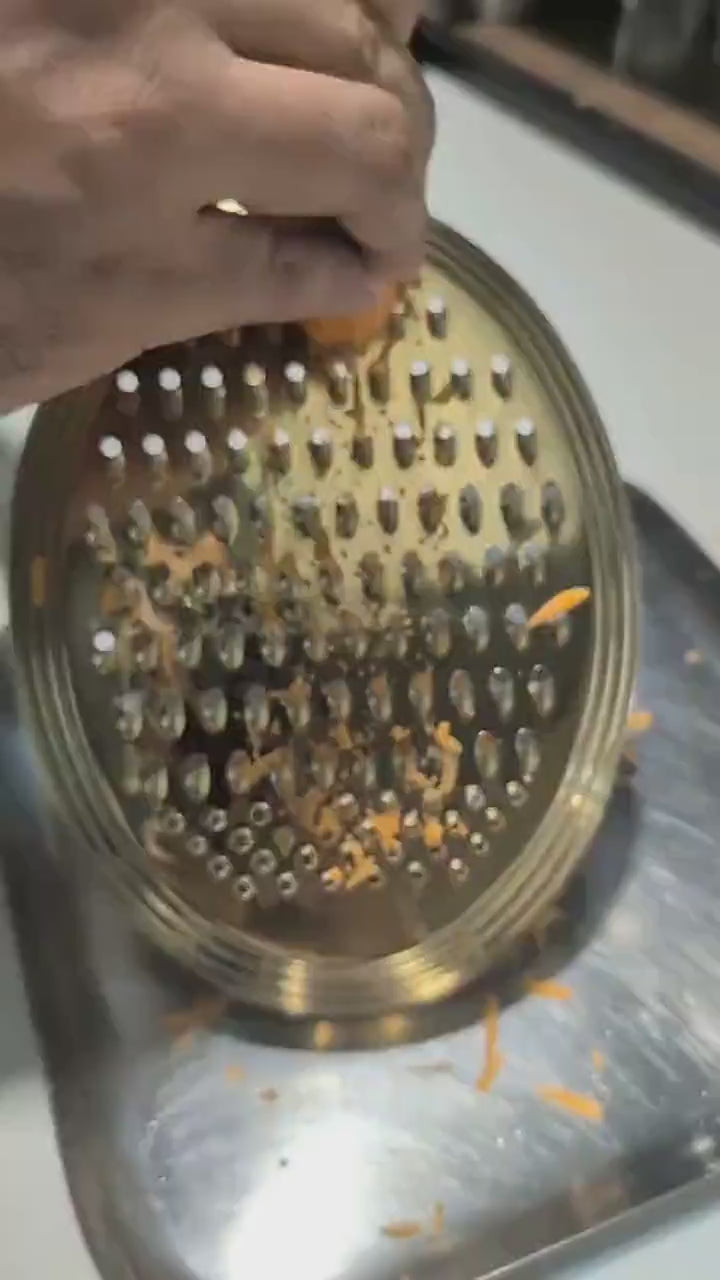 Meshverse gold oval grater shredding fresh carrots